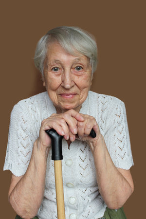 Smiling senior woman relaxing and holding walking stick or cane. hope and dreams conceptの写真素材