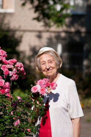 Portrait of a smiling elderly woman. A photo on the nature park backgroundの写真素材