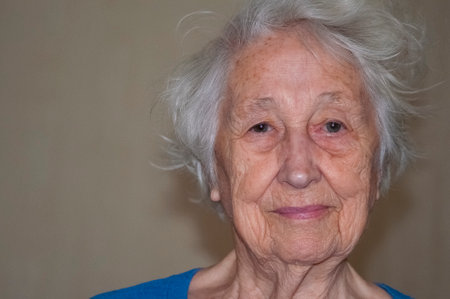 The portrait of a cheerful smiling senior woman over home background