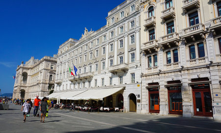 Trieste, Italy - October 1, 2023: The people going at streets of Trieste with the facades of old and...