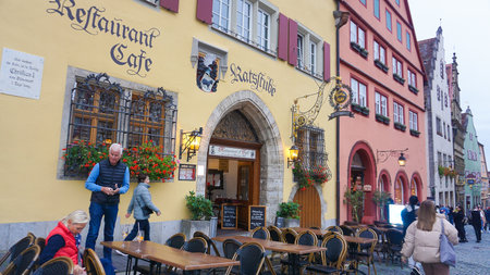 Rothenburg ob der Tauber, Germany - October 20, 2023: People going near historical buildings at Rothenburg ob der Tauber - old fortified city in Germany.のeditorial素材