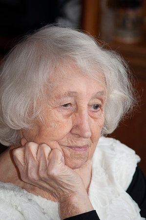 Head shot close up portrait of thoughtful senior woman worrying about personal health problems. Upset older female thinking of family troubles, feeling lonely, sitting at home.の写真素材