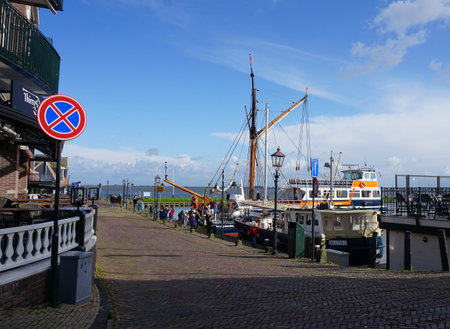 Volendam, Netherlands - April 16, 2024: Volendam,Netherlands. Small town fishing village in North Holland near Amsterdam with traditional houses with red tegular roofs at waterfront with Docks by Seaのeditorial素材