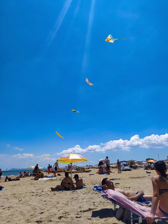 Rimini, Italy - June 25, 2024: People walking along Rimini beach. The sunbeds and parasols on the beachのeditorial素材