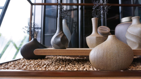 Beige ceramic vases with dry cotton branches. Neutral trendy colors interior decoration in minimal style.の写真素材