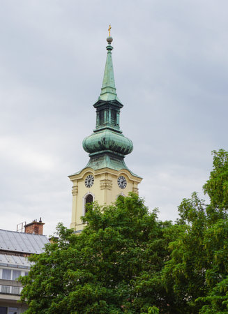 Exterior view of a historical old town building and the beautiful tower of Saint George Martyr Serbian Orthodox Church in the downtown of Budapest, Hungary, Eastern Europe.の写真素材