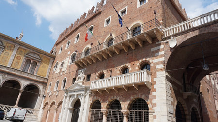 Verona, Italy - May 12, 2025: Palazzo della ragione and torre dei lamberti dominate piazza delle erbe under a cloudy sky in verona, italyの写真素材