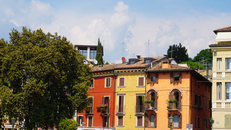 Beautiful traditional Italian building with flowers on balcony of medieval wall at Verona, Italyの写真素材