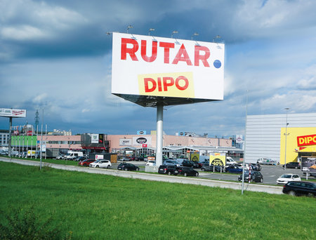Villach, Austria - September 28, 2025: Rutar store sign on pole against clear blue sky and residential buildings.のeditorial素材