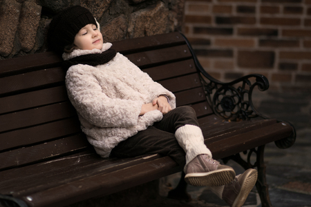 Little fashionable girl in warm clothes in the cityの写真素材