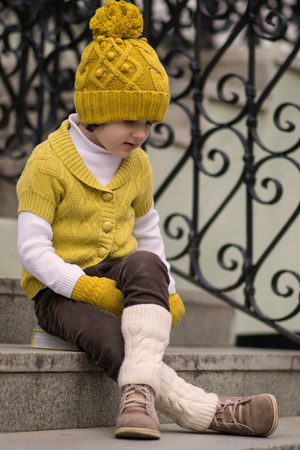 Little fashionable girl in warm clothes in the cityの写真素材