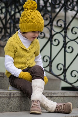 Little fashionable girl in warm clothes in the cityの写真素材