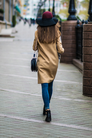 Outdoor portrait of a young beautiful fashionable happy lady posing on a street of the old city. Model wearing stylish clothes. Girl looking up. Female fashion. City lifestyle. Copy space for textの写真素材