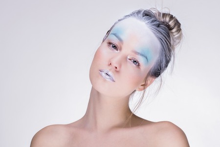 Young winter woman in creative image with silver blue artistic make-up and perfect hairstyle.の写真素材