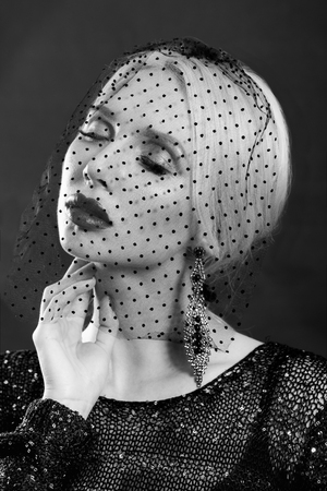 beauty portrait of attractive girl with bright red lips and mesh on the faceの写真素材