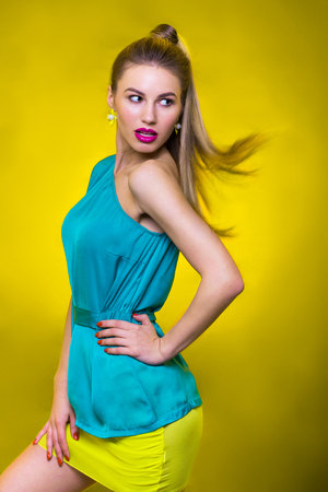 portrait of cheerful fashion girl in etudio on yellow backgroundの写真素材