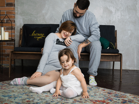 Little girl and his parents kissing. Pregnant woman. So happy familyの写真素材