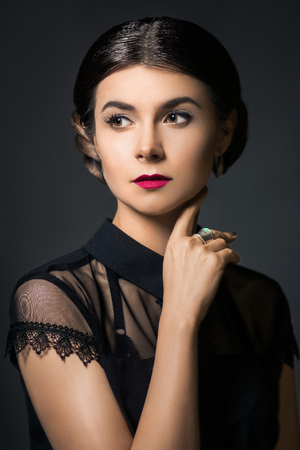 Fashion portrait of young beautiful woman with jewelry and elegant hairstyle. Brunette girl. Perfect make-up.の写真素材