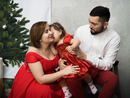 a pregnant woman in a red dress with with her family. Happy New Year.の写真素材