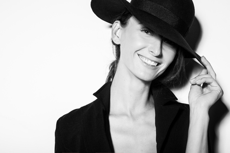 high fashion portrait of elegant woman in black and white hat and dress. Studio shotの写真素材