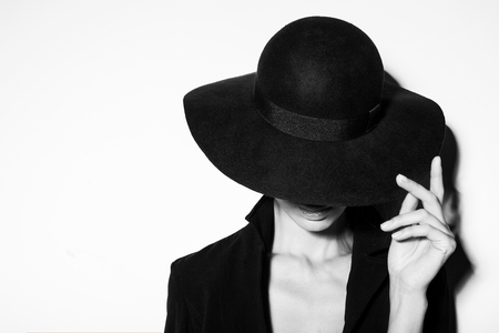 high fashion portrait of elegant woman in black and white hat and dress. Studio shotの写真素材