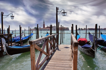 Venice lagoon  Gondolas moored by Saint Mark square with San Giorgio di Maggiore church in the background  Venice, Italy, Europeの写真素材