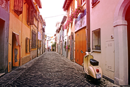 RIMINI, ITALY - June 29, 2013: Vintage scooter parked in a typical narrow old street at sunset in Rimini, Italy. This is the preferred way to travel in old narrow streets of Italyのeditorial素材