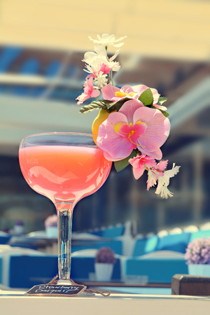 Strawberry Daiquiri Cocktail decorated with pink orchid flowers in a bar on the beachの写真素材