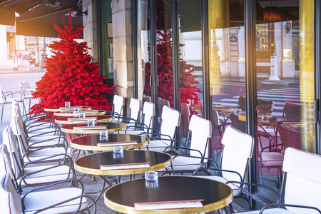 Empty terrace of a typical Parisian cafe and a red Christmas tree on the streets of Paris, Franceのeditorial素材