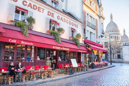 PARIS, FRANCE - DECEMBER 11,2016: View of the church of Sacre Coeur and typical street cafe in the Montmartre district in Parisのeditorial素材