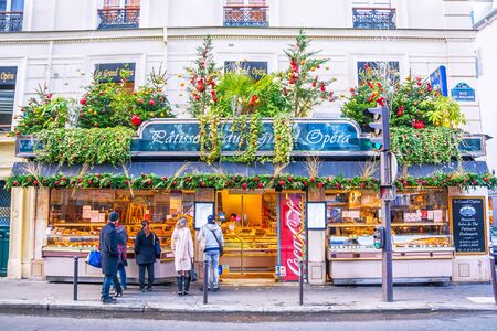 PARIS, FRANCE - DECEMBER 10, 2016: Tourists buy confectionery products at traditional bakery pastry shop decorated for Christmas in the center of Paris.のeditorial素材