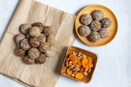 Homemade energy balls with dried apricots, raisins, dates, prunes, walnuts, almonds and coconut. Healthy sweet food. Flat lay, top view.の写真素材