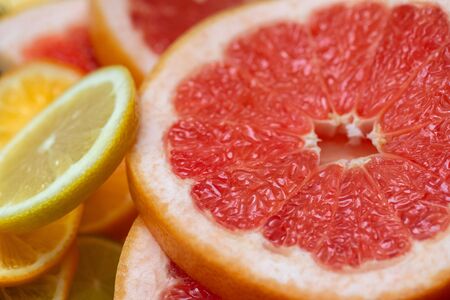 Sliced grapefruit closeup. Fruit background. Fresh citrus grapefruit and lemon, macro. Side view.