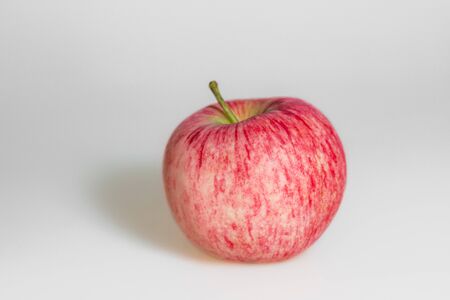 One apple on white background. Red juicy ripe apple close up. Fresh striped fruit. Side view.の写真素材
