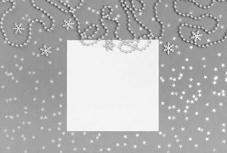 Christmas mockup with silver snowflakes, confetti stars and garland on grey background. Happy New Year. Winter concept. Space for text. Top view, flat lay. Greeting card. Copy space, template.の写真素材