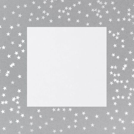 Christmas mockup with silver confetti stars on grey background. Happy New Year. Winter concept. Space for text. Top view, flat lay. Greeting card. Copy space, template.の写真素材