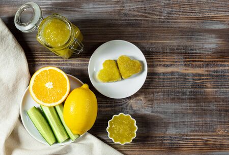 Homemade cucumber jam with lemon and heart-shaped toast on a dark brown wooden background. Copy space. Top view, flat lay.の写真素材