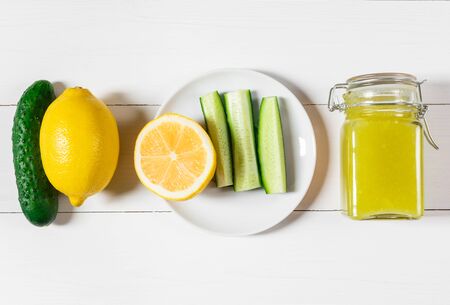 Homemade delicious cucumber jam with lemon in glass jar on white wooden background. Top view, flat lay.の写真素材