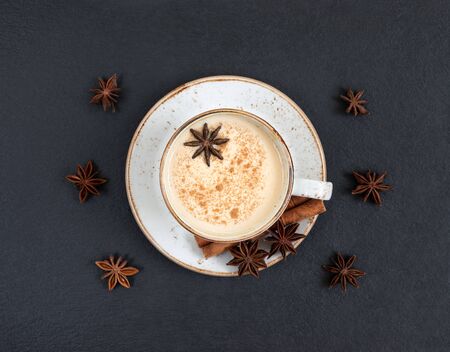Indian Masala chai tea. Traditional Indian hot drink with milk and spices on dark stone table background. Top view, flat lay.の写真素材