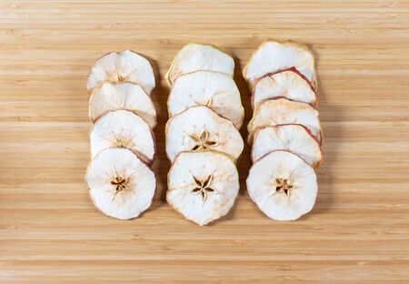 Dried apple chips on a cutting Board background. Natural organic food. Top view, flat lay.