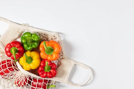 Zero waste concept. Vegetables in eco friendly reusable string bag on white background. Plastic free. Healthy fresh vegetarian food. Flat lay, top view, copy space.の写真素材