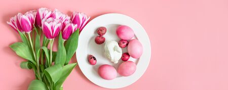 Easter holiday pink table setting with eggs, rabbit and a bouquet of tulips. Banner. Copy space, top...