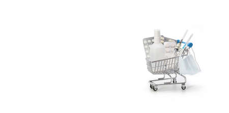 Shopping cart with medicines on a white background. Banner. Concept of protection against coronovirus, covid-19. Pharmacy shopping. Copy space.の写真素材