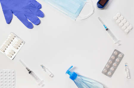 Medical kit. Gloves, syringe, mask, tablets and sanitizer, pulse oximeter on a white background. Means for the prevention and treatment of coronavirus. Covid-19, healthcare concept. Copy space.の写真素材