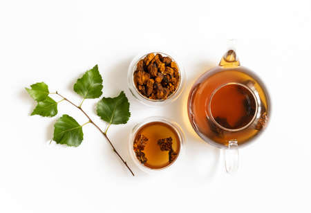 Infusion with chaga mushroom isolated on a white background. Beverage with pieces of birch mushroom in a transparent bowl. Top view, flat lay.の写真素材