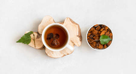 Chaga tea and pieces of chaga mushroom on a white background. Organic infusion with pieces of chaga....