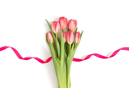 Bouquet of red tulips with pink ribbon isolated on a white background. Mothers Day and Valentines...