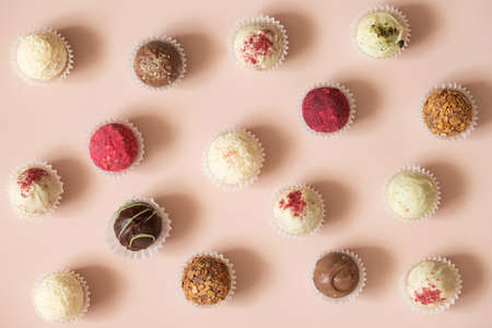 Candy background. Assorted truffles or energy balls on a pink background. Sweets pattern. Top view,...