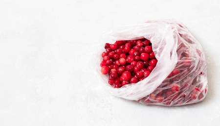 Frozen cranberries in a package close up. Frozen berries on a white background. Homemade preparations. Copy space.の写真素材