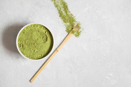 Green matcha tea powder on a gray background. Japanese traditional drink. Vegan healthy drink. Copy space, top view, flat lay.の写真素材